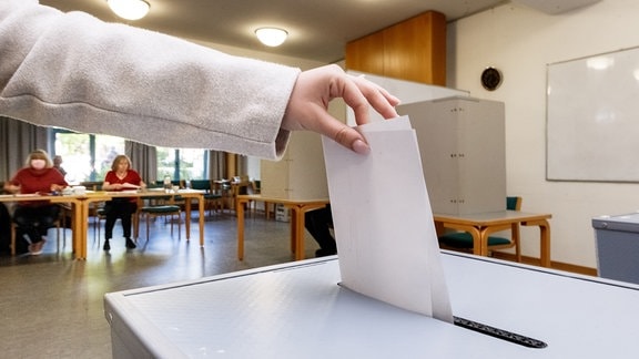 Eine Wählerin wirft 2022 ihren Wahlzettel in die Urne.