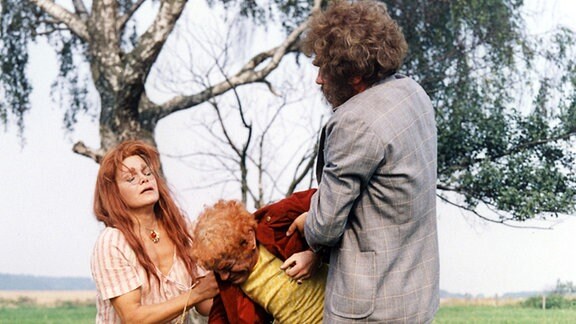 Die Hexe (Katja Paryla), Rumpelstilzchen (Siegfried Seibt) und der Riese (Stefan Lisewski) stehen auf einer Wiese. 
