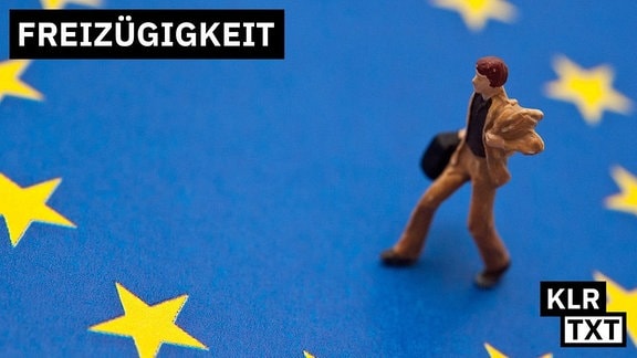 Ein Männchen mit Aktenkoffer steht auf einem EU-Logo