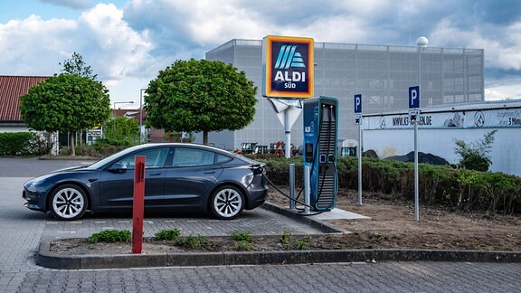 Aufladen eines Elektroautos auf dem Parkplatz des ALDI-Supermarktes in Aachen.