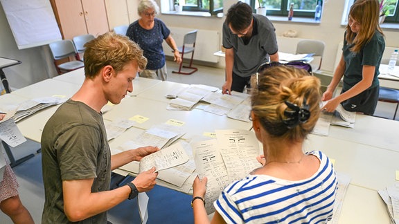 Wahlhelfer im Wahllokal in Leipzig zählen die Stimmzettel der Landtagswahl 2024 aus.