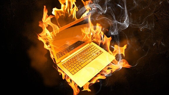 ein brennender Laptop vor schwarzem Hintergrund