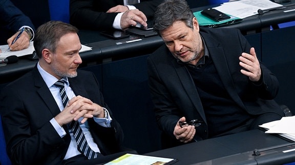 Christian Lindner (l,FDP), Bundesfinanzminister, und Robert Habeck (Bündnis 90/Die Grünen), Vizekanzler und Bundesminister für Wirtschaft und Klimaschutz, unterhalten sich auf der Regierungsbank im Bundestag.