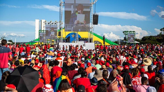 Menscheb verfolgen die Amtseinführung von Lula da Silva auf einer Leinwand