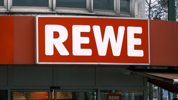 Logo Rewe am Eingang eines Supermarktes 
