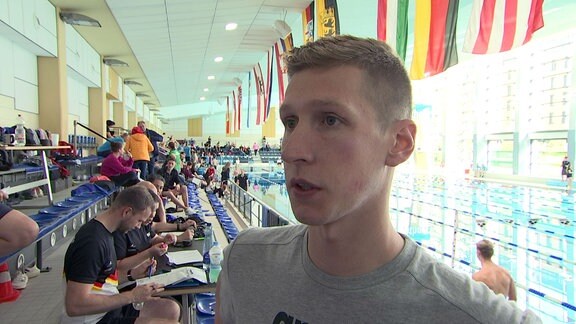 Florian Wellbrock während Interview, im Hintergrund Schwimmbecken.