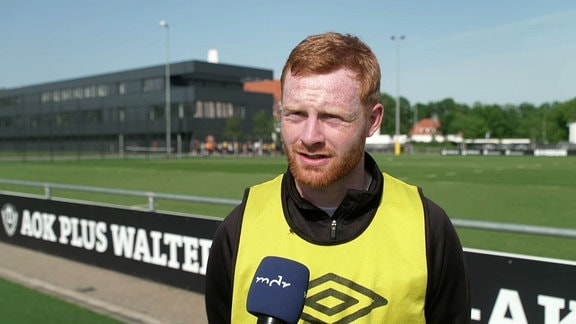Spieler von Dynamo während Interview, im Hintergrund Trainingsplatz.