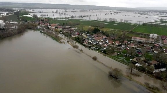 Blick über Hochwassergebiet, im Vordergrund eine Ortschaft.