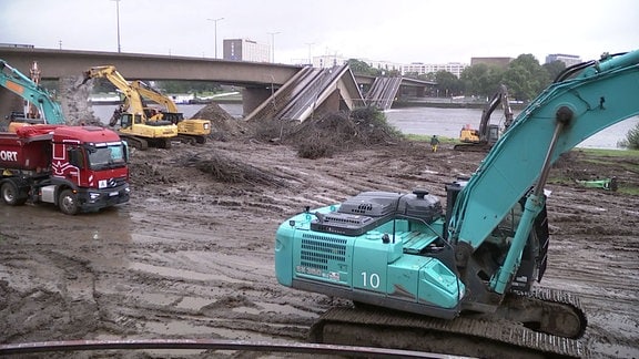 Bagger und Lkw bei Abrissarbeiten an der Carolabrücke.