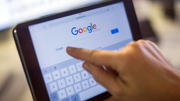 Der Google-Schriftzug und die Google-Suche auf einem kleinen Tablet.