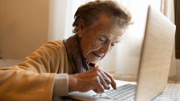 Seniorin arbeitet am Laptop