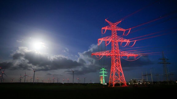 Strom-Masten der Westküstenleitung in Norddeutschland neben dem Tennet-Umspannwerk Klixbüll-Süd: Angestrahlt in den Farben Rot, Grün und Gelb für einen Festakt zur Inbetriebnahme am 4. November 2022