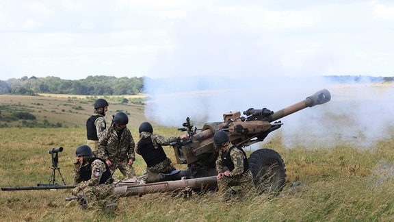 Britische Soldaten unterrichten Mitglieder der ukrainischen Streitkräfte in der Bedienung leichter Geschütze von Typ L119 der neuseeländischen Verteidigungskräfte und der britischen Armee. 