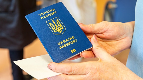 Eine Krankenschwester kontrolliert den Pass eines Patienten aus der Ukraine 