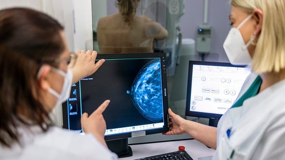 Medizinisches Personal untersucht mit einer Mammografie die Brust einer Frau auf Brustkrebs