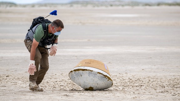 Ein Mann übt die Bergung einer gelandeten Raumkapsel in der Wüste