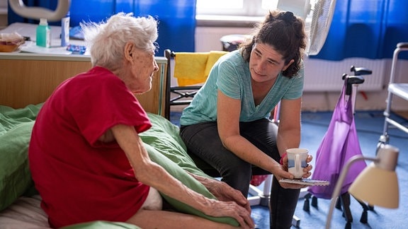  Pflegerin auf Hausbesuch bei einer pflegebedürftigen Seniorin .