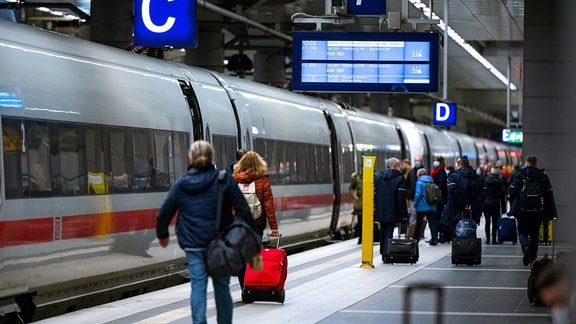 Fahrgäste steigen im Berliner Hauptbahnhof in einen ICE der Deutschen Bahn.