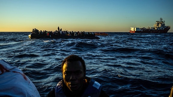 Die von SOS Mediterranee herausgegebene undatierte Aufnahme zeigt ein mit Migranten überfülltes großes Schlauchboot in der Nähe des Seenotrettungsschiffs «Ocean Viking» (r).