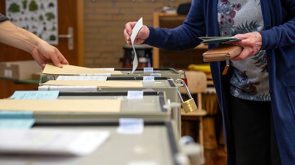 Ein Frau wirft ihren Stimmzettel in die Wahlurne. In Bayern findet am Sonntag die Wahl zum 19. Bayerischen Landtag statt.