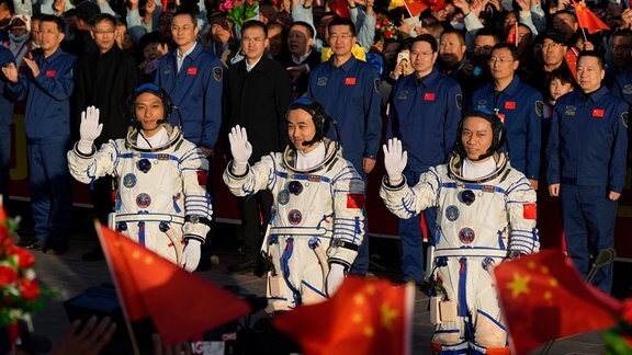 Die chinesischen Astronauten der Shenzhou-17-Mission, Jiang Xinlin, Tang Hongbo und Tang Shengjie, winken bei der Abschiedszeremonie für ihre bemannte Raumfahrtmission im Jiuquan Satellite Launch Center im Nordwesten Chinas.