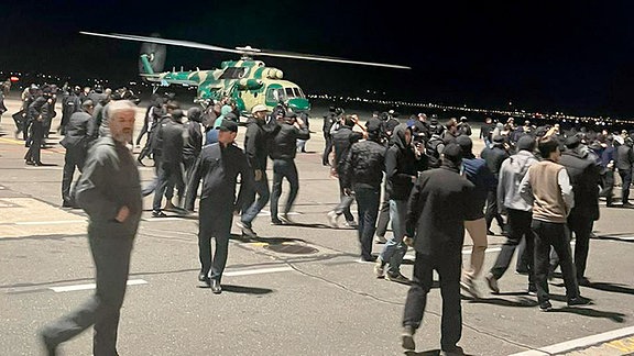 Menschen laufen und rufen antisemitische Parolen auf einem Flugfeld des Flughafens in Machatschkala.