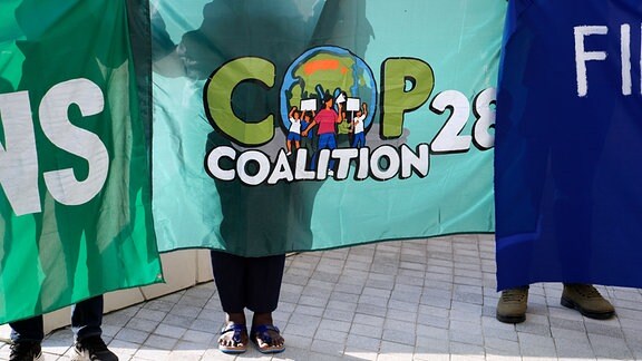Menschen halten ein Zeichen für die COP-Koalition bei der COP28 der Vereinten Nationen.