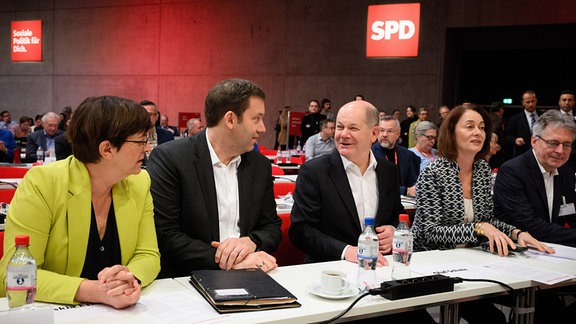 Saskia Esken (l-r), Vorsitzende der SPD, Lars Klingbeil, Vorsitzender der SPD, Bundeskanzler Olaf Scholz (SPD), Katarina Barley (MdEP, SPD) und Achim Post (MdB, SPD) sitzen beim ordentlichen Bundesparteitag der SPD auf dem Berliner Messegelände.
