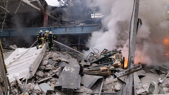 Feuerwehrleute löschen ein Feuer nach einem russischen Angriff.