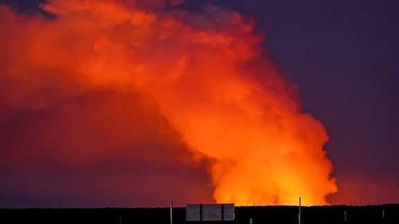 Gaswolke, von der Lava des ausbrechenden Vulkans beleuchtet 