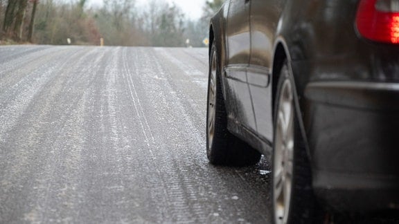 Ein Auto steht auf einer glatten Straße. Schnee und Glatteis haben für erhebliche Verkehrsbehinderungen in Rheinland-Pfalz gesorgt.