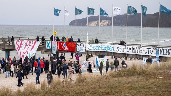 Teilnehmer der Protestaktion "Stoppt LNG auf Rügen" stehen an der Seebrücke des Ostseebades Binz auf der Insel Rügen.
