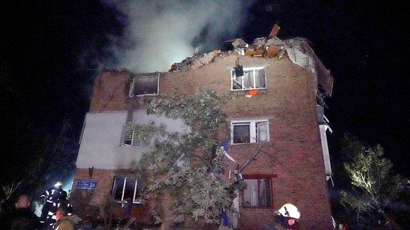 Feuerwehrleute löschen ein Feuer in einem Wohnhaus, das bei einem russischen Raketenangriff beschädigt wurde. 