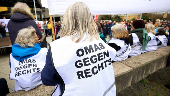 Demoteilnehmerinnen tragen weiße Westen mit der Aufschrift: OMAS GEGEN RECHTS 