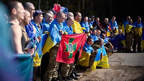 Ukrainer posieren für ein Foto, nachdem sie im Rahmen eines Gefangenenaustauschs an einem ungenannten Ort in der Ukraine freigelassen wurden.