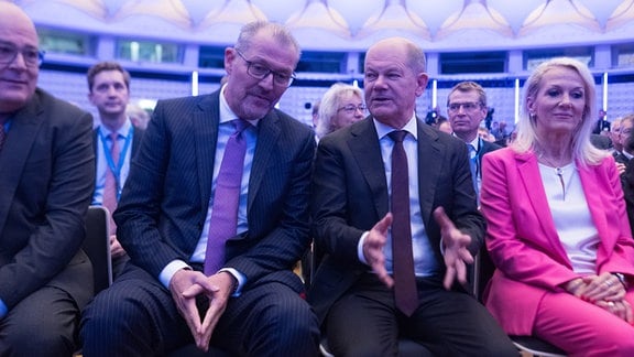 Rainer Dulger (Mitte l), Präsident der Bundesvereinigung der Deutschen Arbeitgeberverbände, und Bundeskanzler Olaf Scholz (SPD) sprechen während des Deutschen Arbeitgebertages 2024 der Bundesvereinigung der Deutschen Arbeitgeberverbände (BDA)