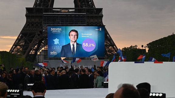 Eine Multimediatafel zeigt President Macron in Paris