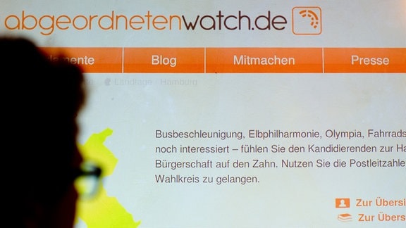 Ein Mann schaut sich während eines Pressetermins die mit einem Beamer an die Wand projizieren Internetseite «abgeordnetenwatch.de» an. 