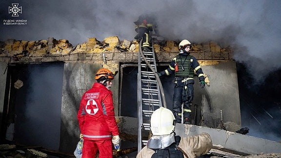 Auf diesem vom ukrainischen Katastrophenschutz zur Verfügung gestellten Foto arbeiten Feuerwehrleute an einem brennenden Gebäude nach einem russischen Angriff.