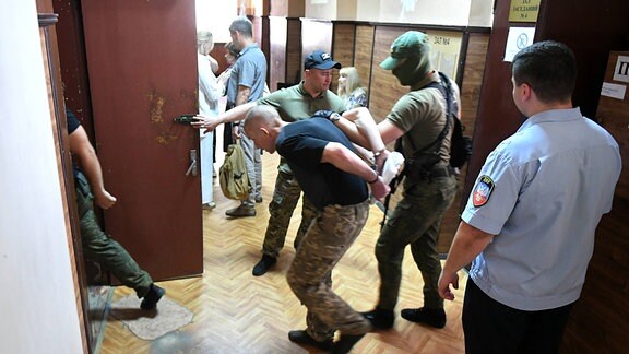 Britischer Kämpfer wird zur Anhörung in das Oberste Gericht von Donezk geführt