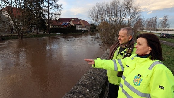 Antje Hochwind-Schneider (r, SPD), Landrätin des Kyffhäuser Kreises, und Bernhard Stengele (Die Grünen), Thüringer Minister für Umwelt, Energie und Naturschutz, informieren sich über die aktuelle Hochwasserlage am Ufer des Flusses Helme.