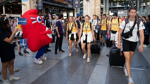 Deutsche Athleten sowie deren Trainer und Betreuer werden am Tag ihrer Abreise nach Abschluss der Olympischen Spiele am Bahnhof Gare du Nord von den Mitarbeitern des Schnellzugbetreibers Eurostar und dem Olympia-Maskottchen Phryges verabschiedet.