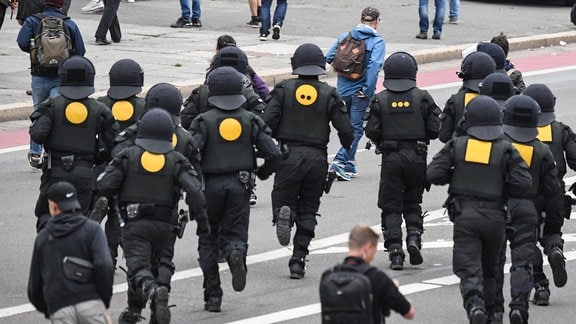 Polizisten rennen 2018 am Rande der Demonstration von AfD und dem ausländerfeindlichen Bündnis Pegida, der sich auch die Teilnehmer der Kundgebung der rechtspopulistischen Bürgerbewegung Pro Chemnitz angeschlossen haben, zu einem Einsatz.