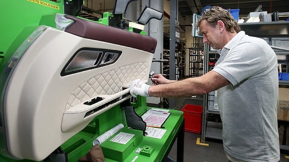 Ein Mitarbeiter überprüft eine Türverkleidung für einen Mercedes Benz AMG SLS, 2014, bei der  Eissmann Automotive GmbH in Gera.