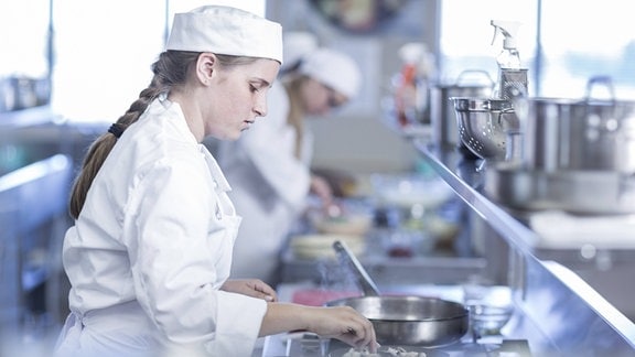 Eine junge Frau arbeitet in der Küche