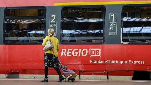 Eine Frau geht an einem Regionalexpress auf dem Hauptbahnhof Leipzig entlang. Die Menschen in Sachsen können ab diesem Montag das 9-Euro-Ticket für den öffentlichen Nahverkehr kaufen. Der Fahrschein ist in der Regel an Automaten, Verkaufsstellen oder bei Busfahrern erhältlich und gilt ab 1. Juni bundesweit.