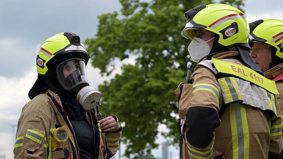 Feuerwehrleute beraten sich während des Brandes einer Fabrik in Berlin-Lichtenfelde. 