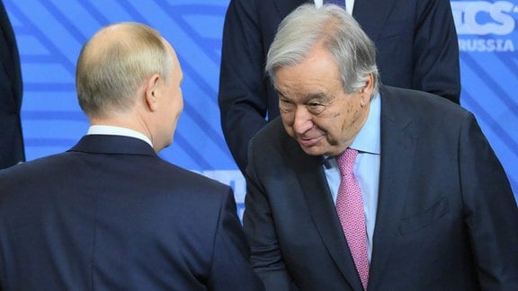 Der russische Präsident Wladimir Putin (links) und der Generalsekretär der Vereinten Nationen, Antonio Guterres, geben sich während der Familienfotozeremonie vor der Sitzung im Outreach/BRICS-Plus-Format am Rande des BRICS-Gipfels in Kasan die Hand