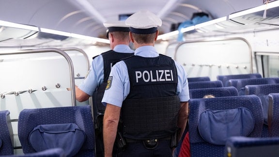 Bundespolizisten gehen am Hauptbahnhof durch einen ICE der Deutschen Bahn (DB).