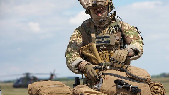 Ein Kommandosoldat des Kommando Spezialkräfte (KSK) der Bundeswehr mit Teilen seiner persönlichen Ausrüstung